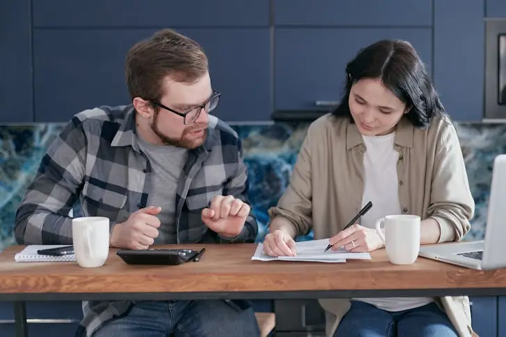 How to cash paper savings bonds - Couple sitting at table with documents.